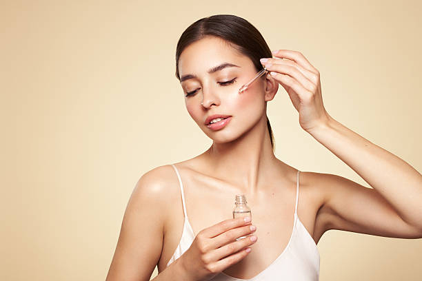istock Young beautiful woman applying face serum 2212537069