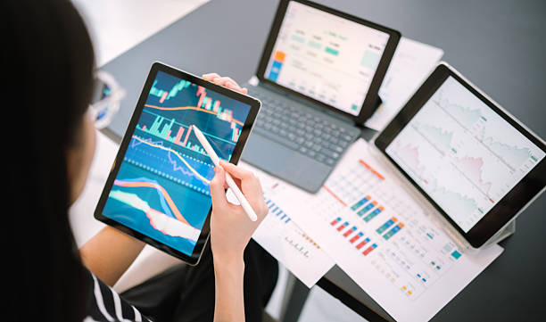 istock Gen Z Woman business professional using smartphone with laptop and documents in multitasking office setup while managing charts and reports at work desk 2212537497