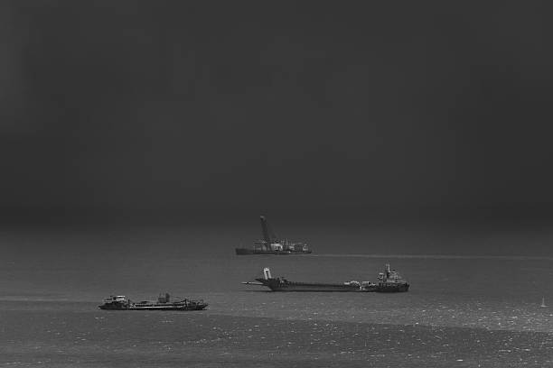 istock black and white, work ship floating in sea, rainstorm backgrounds, 2212537502