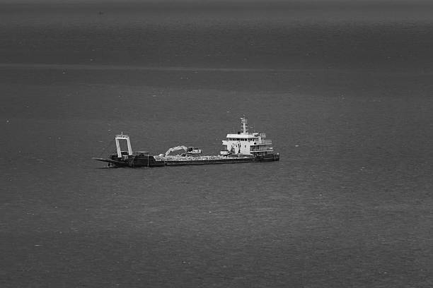 istock black and white, work ship floating in middle of the sea, 2212537516