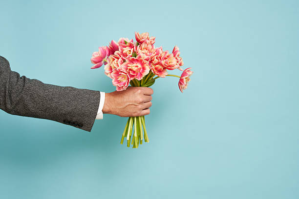 istock Romantic man presents a bouquet of tulips 2212538500