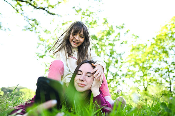 istock Mother and daughter taking a selfie while lying in grass 2212540318