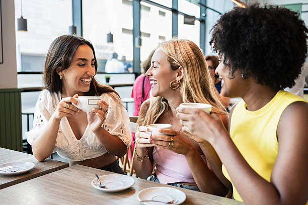 istock Happy girls drinking a coffee and laughing while chatting relaxed 2212540400