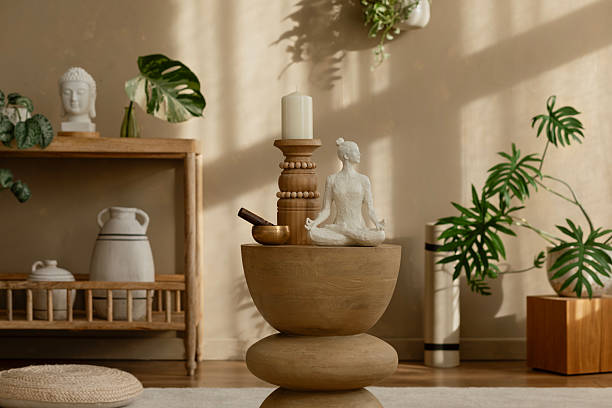 istock Minimalist meditation setup with a wooden sculpture, candle, and natural decor elements on a wooden pedestal. Warm light creates a serene, calming atmosphere. 2212541218