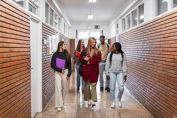 istock High school students walking and talking in school corridor 2212546342