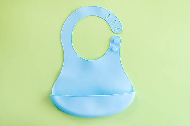 istock Blue silicone baby bib on light green background 2212546781