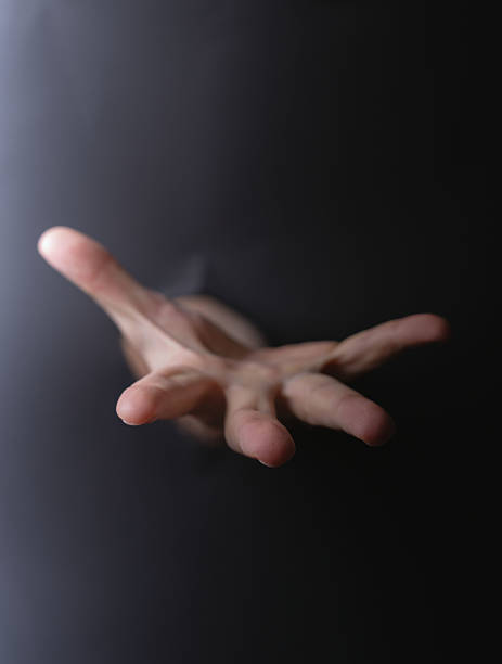 istock photo Outstretched human hand reaching and emerging from darkness with open fingers seeking help, connection or assistance in mysterious and dramatic black background 2212548921