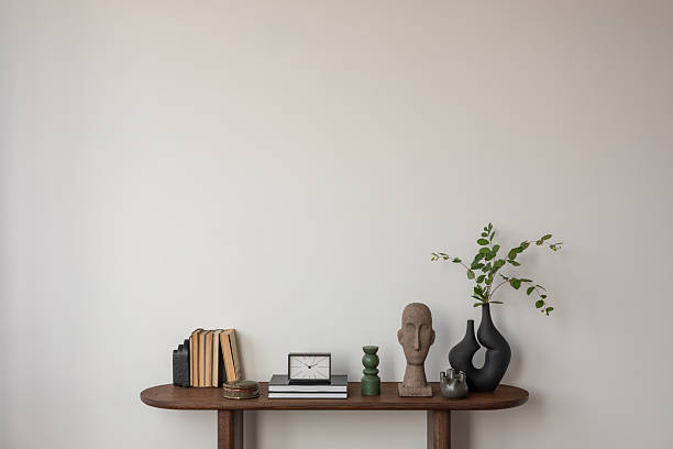 istock Simple console table arrangement with books, modern sculpture, and greenery. A refined blend of form and function.. 2212549654