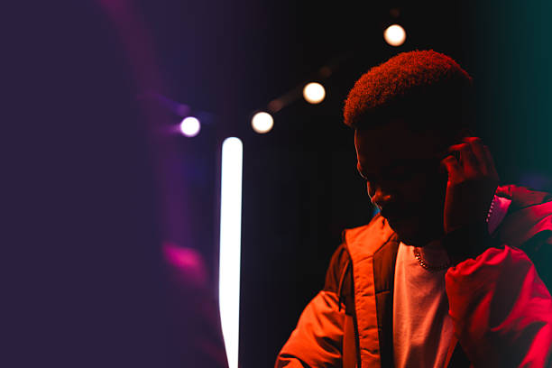 istock Young man focused on DJ equipment in a vibrant nightclub setting during an evening event 2212554055