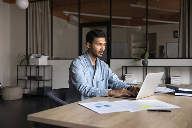 Authentic Indian businessman in his 30s stays busy with analysis