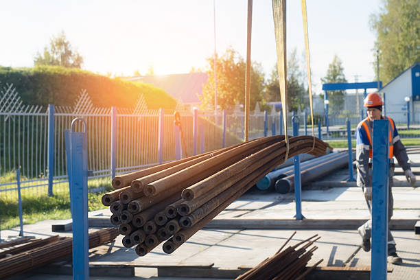 istock Construction site with steel pipes and female worker at sunrise 2212555870