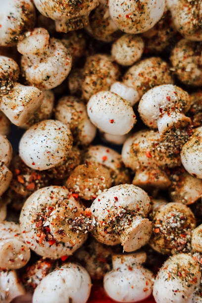 istock Mushrooms seasoned with spices ready for grilling or roasting at a kitchen counter 2212558563