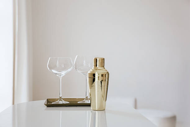 istock Elegant cocktail preparation with golden shaker and glassware on a minimalistic table 2212558846