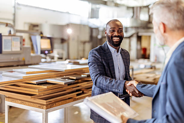 istock Business Professionals Shaking Hands in an Industrial Workspace Setting 2212560367