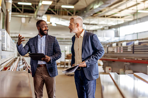 istock Two Businessmen Discussing Operations in a Modern Industrial Facility 2212560518