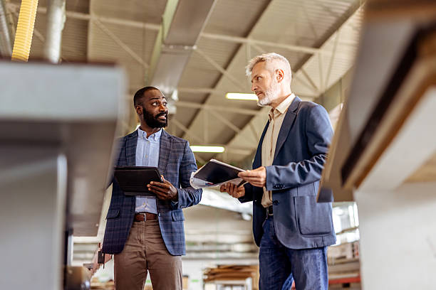 istock Business Colleagues Discussing Work in a Modern Industrial Facility 2212560545
