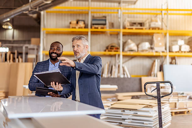 istock Two Business Professionals Discussing Plans in a Warehouse Setting 2212560932