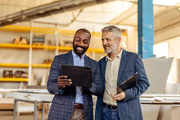 istock Two Business Professionals Discussing Plans Using a Tablet in a Modern Warehouse 2212561293