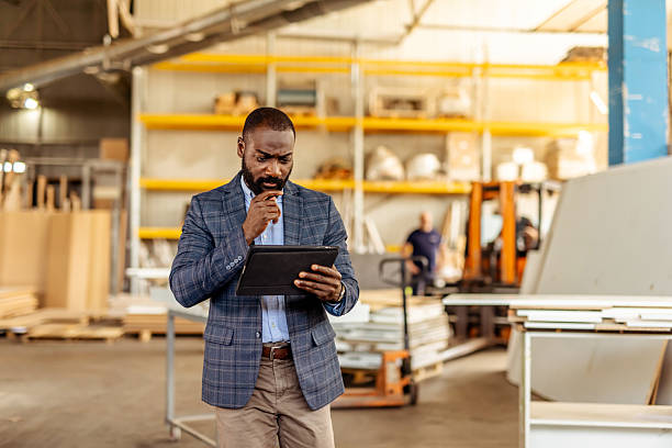Business Professional Evaluating Information on a Digital Tablet in a Warehouse