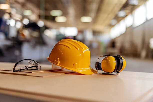 Yellow Hard Hat, Protective Glasses, and Earmuffs in Industrial Setting
