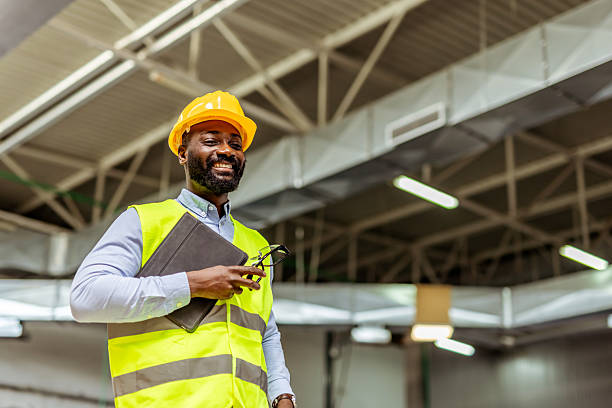 istock Smiling Construction Worker in Safety Gear Inside Modern Industrial Facility 2212566713