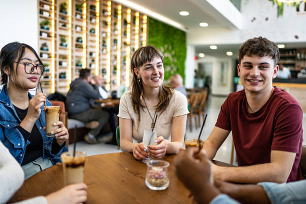 istock Young adults enjoying drinks and conversation at a cafe 2212566957