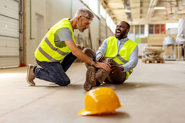 istock Worker Assisting Injured Colleague in Warehouse Accident Situation 2212568708