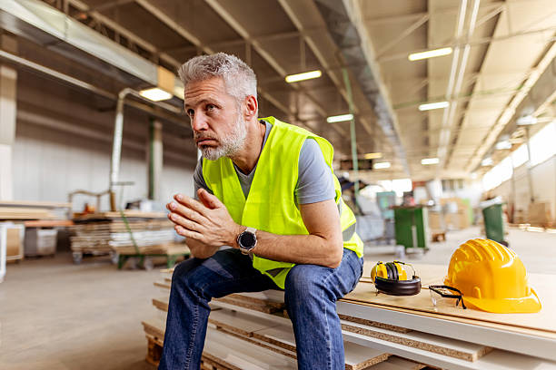 istock Construction Worker Contemplating in a Busy Industrial Workspace 2212570444