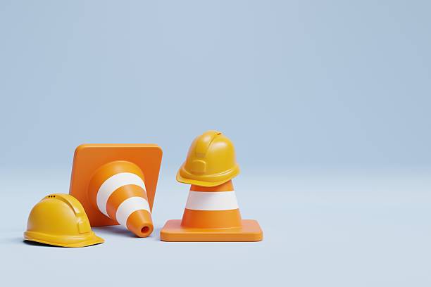 istock Construction Safety Cones and Helmets on Light Blue Background 2212571701