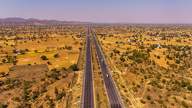 istock drone view of highway surrounded by greenery 2212571735