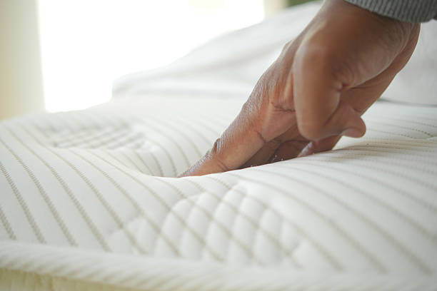 istock Hand touching and pressing orthopedic mattress on bed. 2212573005