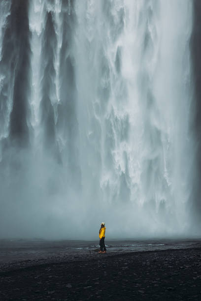 istock Traveller in Yellow Admiring Dramatic Landscape with Waterfall View in Iceland 2212573507