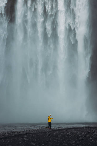 istock Traveller in Distance Making Selfie With Unbelievable Landscape and Waterfall View 2212573542