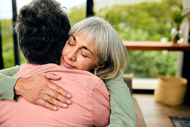 istock Cheerful senior couple at home on couch, smiling towards camera 2212575096
