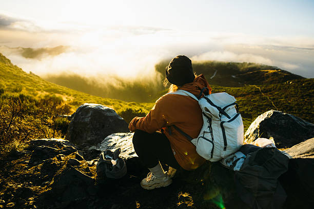 istock Traveller with backpack contemplating sunrise over scenic mountains 2212581220