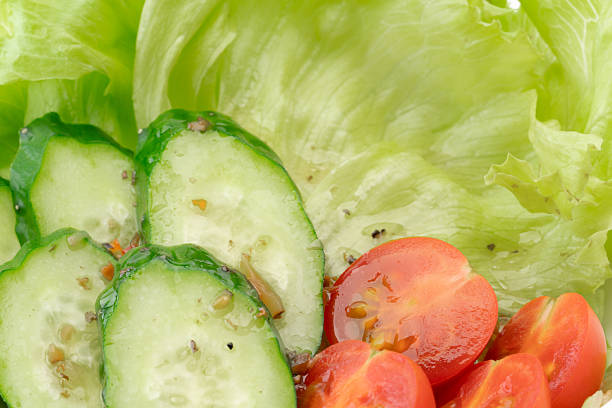 Salad with lettuce, cucumber, and cherry tomatoes topped with dressing