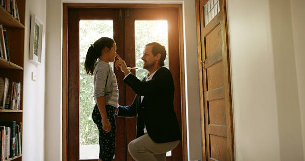 istock Goodbye, door or businessman with kid in home for welcome, affection or return from work trip. Playing, parent and dad in house for leaving, farewell and bonding together with girl, care and love 2212585461