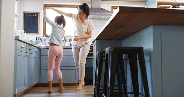 istock Happy, mother and child dancing in kitchen with holding hands, spinning or teaching steps. Family, woman dancer or girl kid with music for movement, learning and relationship with love, care or trust 2212585501