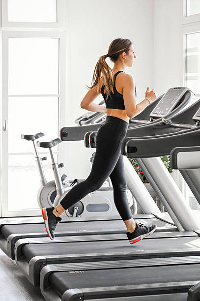 istock Woman Running on Treadmill in Modern Gym 2212586823