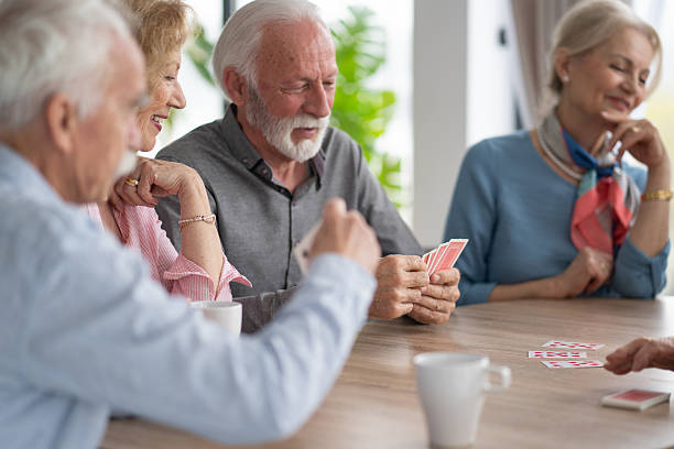 istock Elderly friends engaging in a card game with joy 2212586881