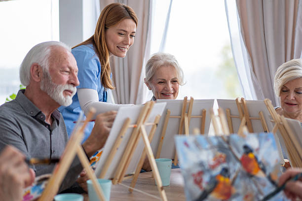 istock Seniors Enjoying Interactive Painting Session with Caregiver 2212586902