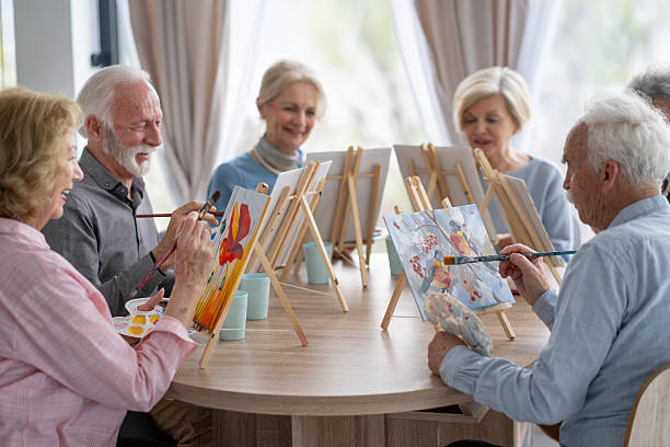 istock Seniors creating art in a cheerful painting session 2212586960