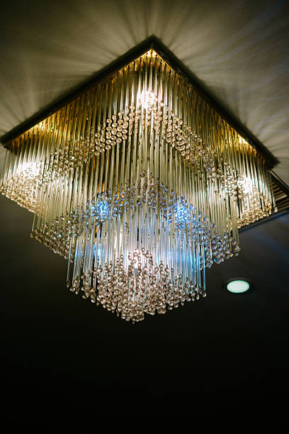 istock Elegant square crystal chandelier hanging from a dark ceiling 2212587635