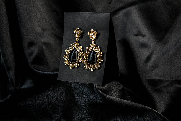 istock Elegant Black and Gold Teardrop Earrings on Satin 2212588861