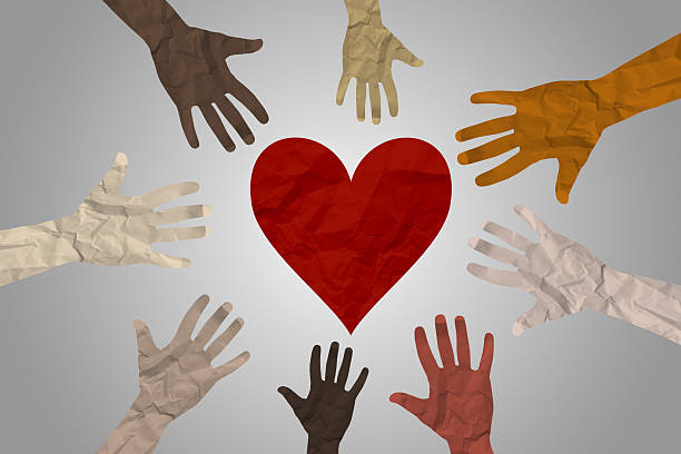 istock Diverse human hands reaching and holding heart 2212589837