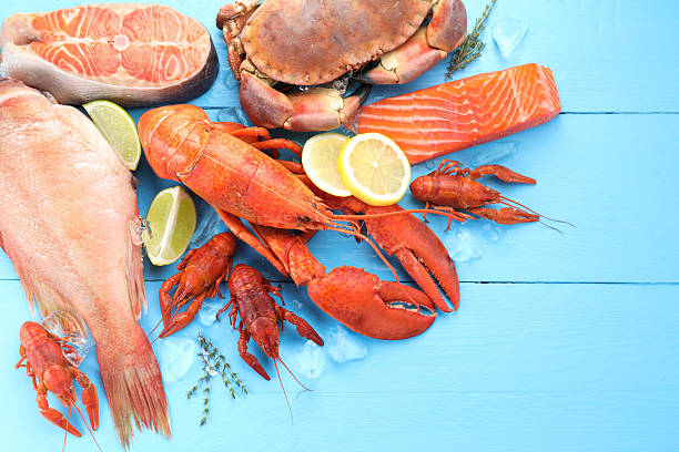 istock Different sea food on light blue wooden table, flat lay 2212591103
