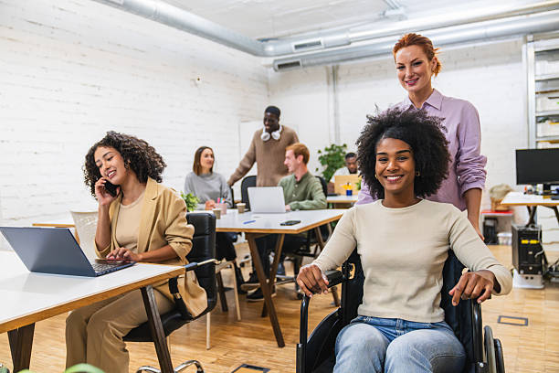 istock Multiethnic creative people working in coworking space with disabled woman 2212593052