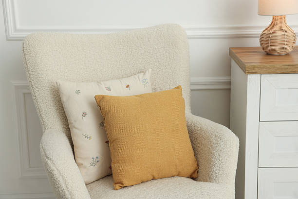 istock Two soft pillows on light armchair indoors 2212593845