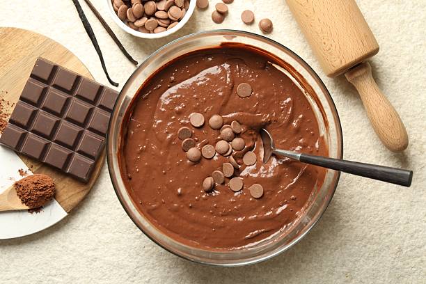 istock Melting chocolate chips for dough in bowl on light table, top view 2212594006