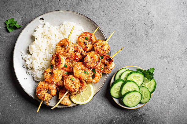 istock Grilled shimp prawn satay skewers with steamed rice 2212594220